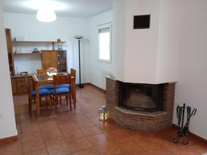 sala de estar con chimenea, mesa y sillas en Vivienda adosada , con merendero en Carcedo, en Carcedo de Burgos