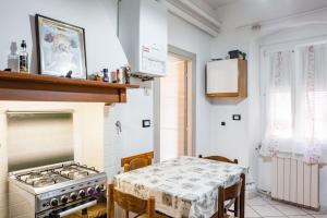 cocina con fogones y mesa con mantel. en La Serra cozy apartment with sea view! en Lerici