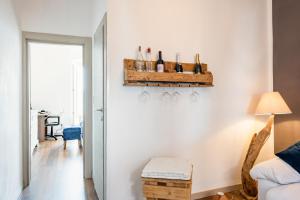 Habitación con pared blanca y estantería con botellas de vino en La Serra cozy apartment with sea view! en Lerici