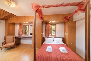 Schlafzimmer mit einem Bett mit einer roten Tagesdecke in der Unterkunft Villa Rodia by PosarelliVillas in Kipárissos