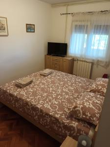 sypialnia z łóżkiem i telewizorem w pokoju w obiekcie Apartment Emma w mieście Rijeka