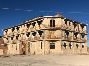 ein altes Gebäude mit Balkon darüber in der Unterkunft HOTEL CASONA DE SAL in Uyuni