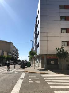a person riding a bike down a street next to a building at Apartamento puerto Benicarlo in Benicarló