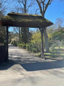 een paviljoen met bladeren erop in een park bij Ferienhaus unter Reet im Heidedorf Sankt Dionys bei Lüneburg in Sankt Dionys