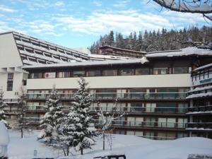 a building in the snow with a tree in front of it at Confortable 2 pièces cabine au pied des pistes - 7 pers, balcon, ascenseur - FR-1-411-708 in Bourg-Saint-Maurice
