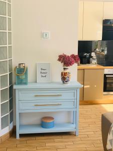 a blue dresser with a vase on it in a kitchen at Malva Sun dog friendly Apartment with garden in Kołobrzeg