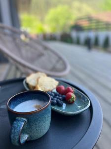 eine Tasse Kaffee und einen Obstteller auf dem Tisch in der Unterkunft Mountain View in Govedartsi