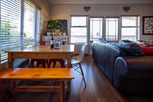 a living room with a table and a couch at Modern Shabby Chic Apartment in Durbanville