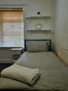 a bed sitting in a bedroom with a window at Knighton House in Leicester
