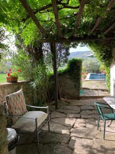 un patio con mesa y sillas bajo una pérgola en Il Sole Del Sodo, en Cortona