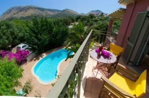 a balcony of a house with a swimming pool at Stamoulis Villas in Ayia Evfimia