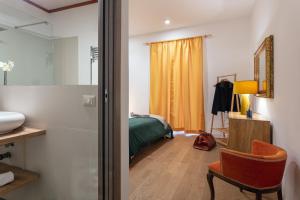 ein Schlafzimmer mit einem Bett, einem Spiegel und einem Stuhl in der Unterkunft Starguest La Sapienza art Gallery in Neapel