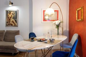 ein Esszimmer mit einem Tisch und blauen Stühlen in der Unterkunft Starguest La Sapienza art Gallery in Neapel