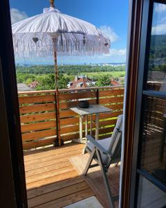 a patio with a table and an umbrella and a chair at Jules&Jim Gästehaus in Linz