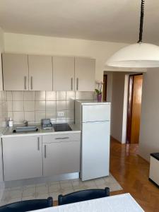 eine Küche mit weißen Schränken und einem weißen Kühlschrank in der Unterkunft Apartment Ivan in Vantačići