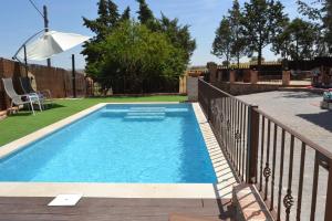 a swimming pool in a yard with a fence at Casa Rural La Finca in Guadamur