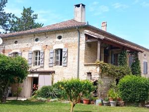 an old brick house with plants in the yard at La maison du pech in Monteils