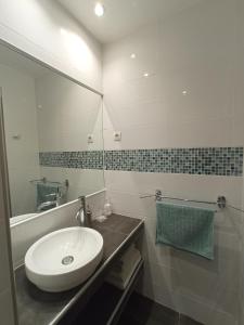 een badkamer met een wastafel en een spiegel bij La maison du pech in Monteils