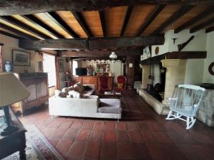 a living room with a white couch and a fireplace at La maison du pech in Monteils