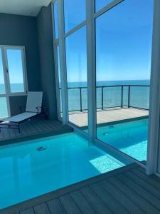 a swimming pool in a room with a view of the ocean at Dpto con vista increible 102 in Mar del Plata