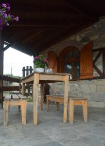a wooden table and benches in front of a building at Mountain House Kastro in Kástron +23 photos