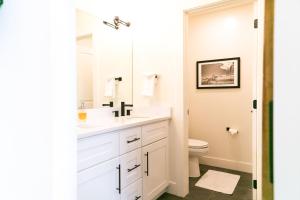 La salle de bains est pourvue d'un lavabo blanc et de toilettes. dans l'établissement LUX Modern Chalet, Pool & Hot Tub, 10 Mins to the Mountain & Incredible Views, à Whitefish