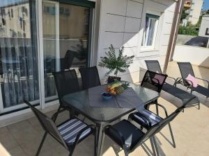 a table and chairs on a balcony with a bowl of fruit at 3 bedroom apartment with terrace and free parking in Split