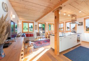 a kitchen and living room with wooden ceilings at Chalet Stella Duplex Penthouse in Wengen