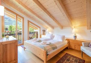 a bedroom with a bed and a large window at Chalet Stella Duplex Penthouse in Wengen
