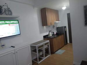 カガヤン・デ・オロにあるStudio Condo at The Loop Tower, Limketkai Dr, Cagayan de Oro Cityのキッチン(カウンター、冷蔵庫付)が備わる客室です。