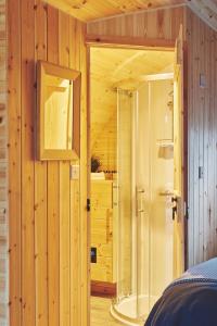 y baño con ducha en una pared de madera. en Hidden Orchard, en Chester