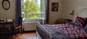 um quarto com uma cama, uma mesa e uma janela em Domaine du Castellare em Le Chalard