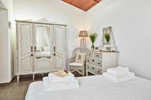 a white bedroom with a bed and a dresser at Casa Recanto da Horta - Casas com EnCanto in Reguengos de Monsaraz