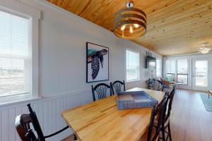 - une salle à manger avec une table et des chaises en bois dans l'établissement Salty Air, à Gulf Shores