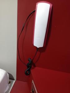 eine rote Wand mit einem wii-Controller an einer Wand befestigt in der Unterkunft Hotel Lalique in São Paulo