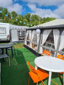 a patio with a table and chairs and a caravan at CHAŁUPY 6 VisitHel in Chałupy