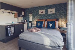 比尔Escape Pod in Devon, 5 mins from beach + parking的一间卧室配有蓝色和橙色枕头的床