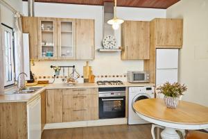 a kitchen with wooden cabinets and a wooden table at Casa Recanto da Horta - Casas com EnCanto in Reguengos de Monsaraz