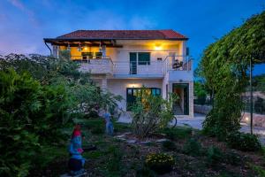 a house with two kids in front of it at APARTMENT AMELIA VRPOLJE in Vrpolje