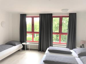 1 Schlafzimmer mit 2 Betten und einem großen Fenster in der Unterkunft Zu Gast im Mehrgenerationenwohnen in Kempten