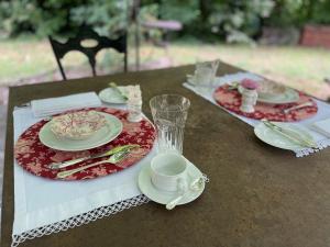 una mesa con dos platos y una taza y un platillo en Casina Morgana B&B en Novafeltria