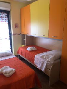 a room with two beds and cabinets and a window at Casa di Taty - Home resort in Policoro