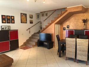ein Wohnzimmer mit einer Treppe und einem TV in der Unterkunft Casa di Taty - Home resort in Policoro