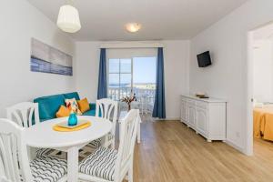 een woonkamer met een tafel en stoelen en een slaapkamer bij Apartamento Castellsol 106 in Arenal d'en Castell