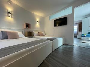 a bedroom with two beds and a tv on the wall at Hotel and the City, Empire State Building in New York