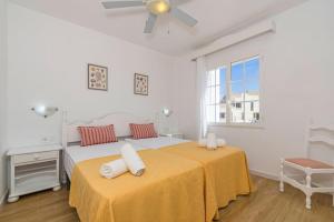 Dos camas en una habitación blanca con ventana. en Apartamento Castellsol 106, en Arenal d'en Castell 10 fotos más