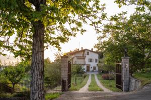 an entrance to a house with a gate and a tree at Apartma ODDIH in Dutovlje
