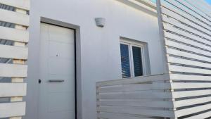 a white house with stairs and a door at House Relax Marzamemi in Noto