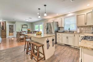 a kitchen with white cabinets and a kitchen island with bar stools at East Stroudsburg Home with Fire Pit and Private Pond in East Stroudsburg