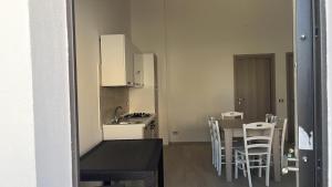 a kitchen and dining room with a table and chairs at House Relax Marzamemi in Noto
